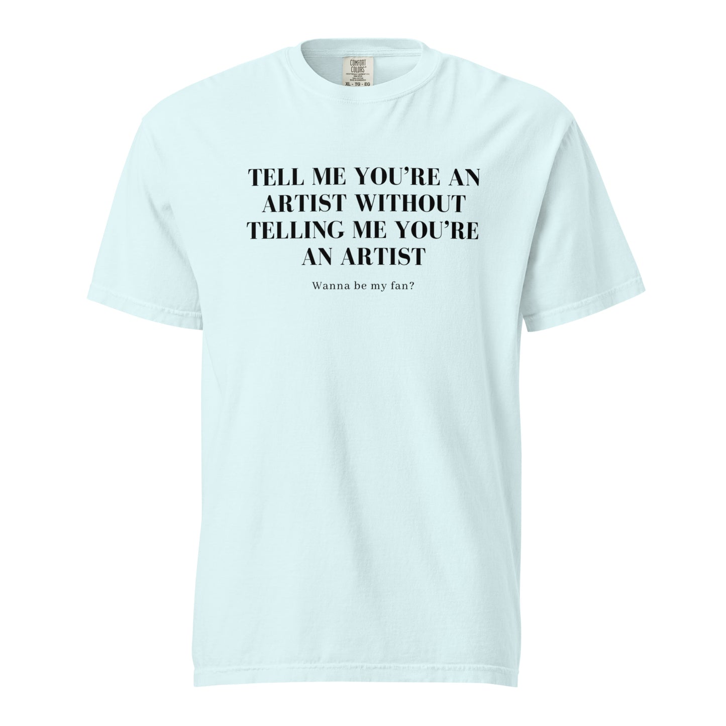 Image of the new meme tee from the Let 'Em Know Collection, featuring bold text that reads: 'Tell me you're an artist without telling me you're an artist. Wanna be my fan?' Plus, choose between plain and SpotlYght Seeker tags!