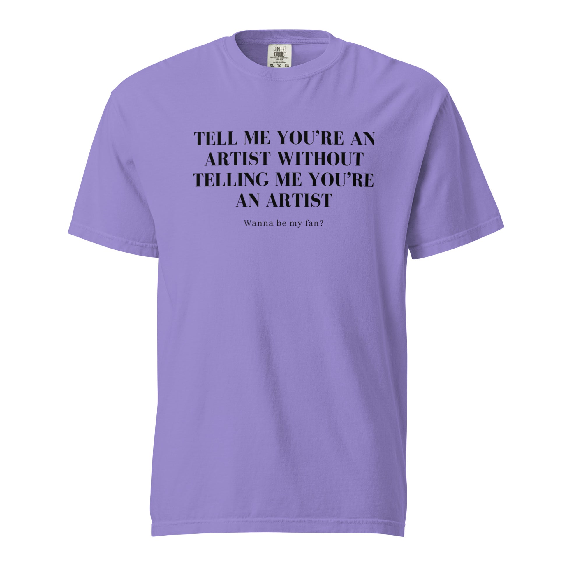 Image of the new meme tee from the Let 'Em Know Collection, featuring bold text that reads: 'Tell me you're an artist without telling me you're an artist. Wanna be my fan?' Plus, choose between plain and SpotlYght Seeker tags!