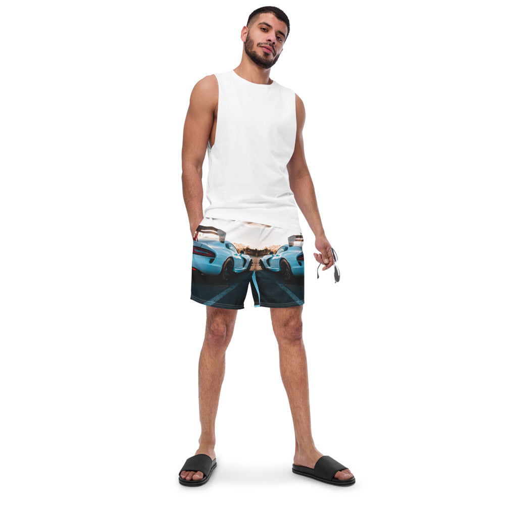 Male artist confidently stands out in vibrant race car swim trunks from SpotlYght Seeker, symbolizing success and creative expression. Skrrt your way to style and savings!